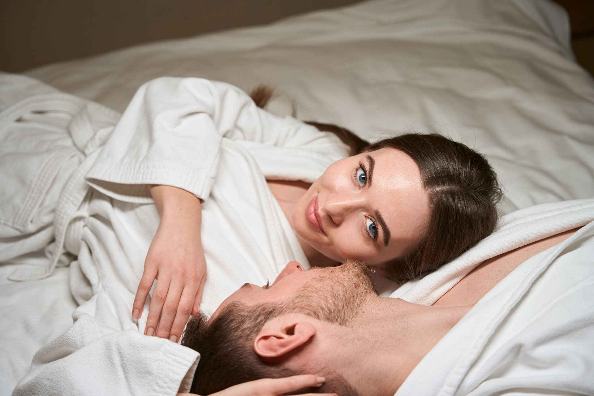 Serene female resting with man in bedroom