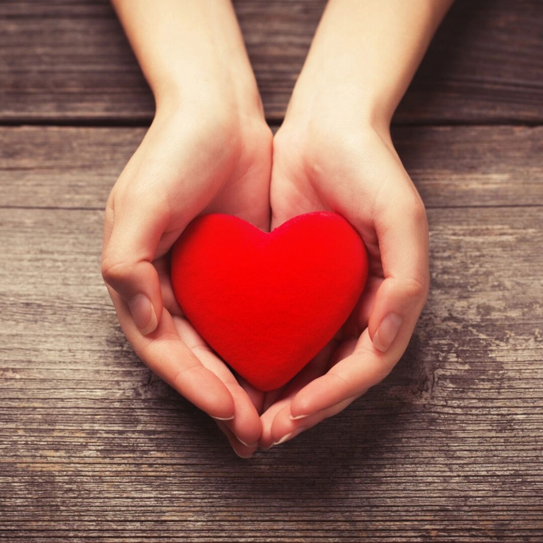 A person holding a heart in their hands.